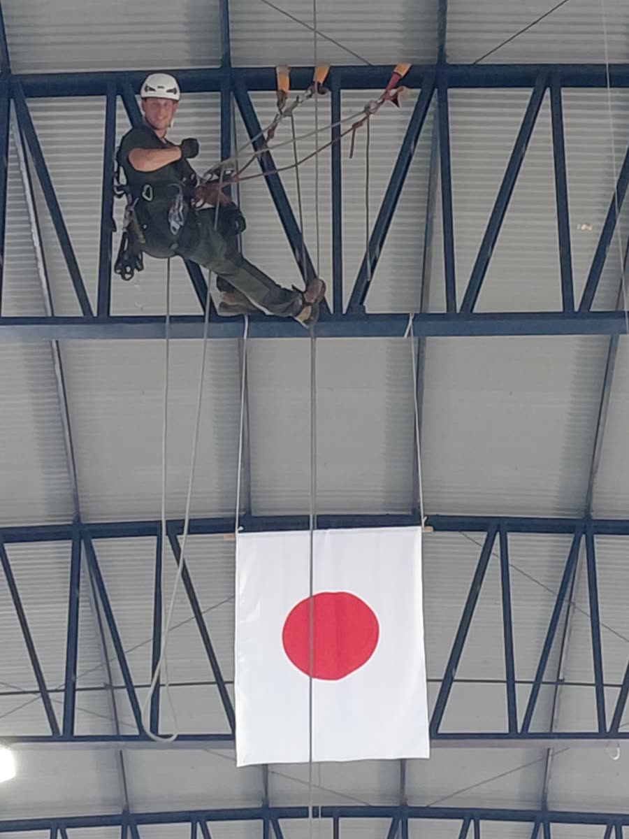 Técnico posicionado na treliça acima da bandeira do Japão