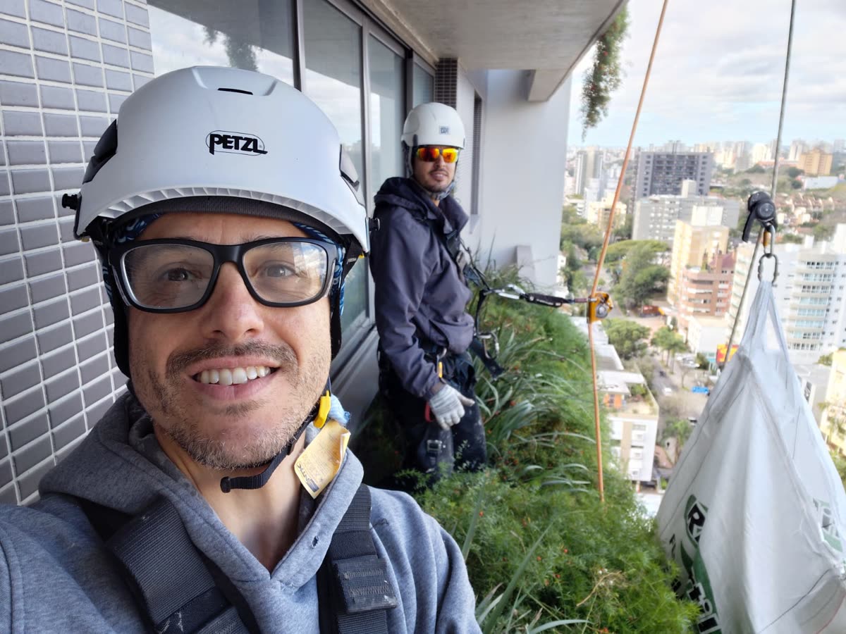Equipe trabalhando no jardim vertical no alto do prédio