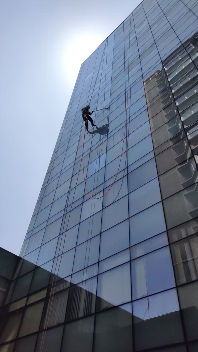 Limpeza de vidros em torre envidraçada com acesso por cordas