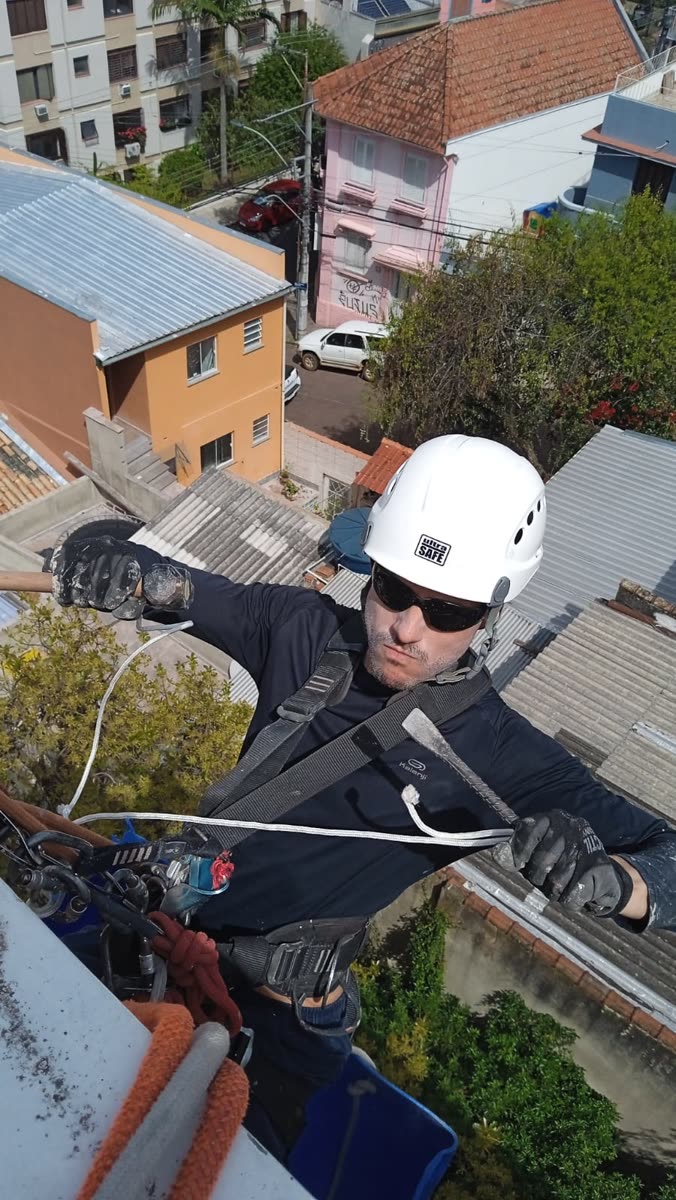 Técnico em acesso por cordas fazendo reparo na fachada